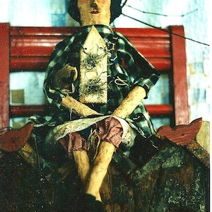 May include: A rag doll with a plaid shirt and a birdhouse on its chest sits on a red wooden chair. The doll has a brown and white face and a crown of twigs on its head.