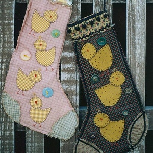 May include: Two handmade fabric stockings with a patchwork design. One stocking is pink with yellow chicks and buttons. The other stocking is black with yellow chicks and buttons.