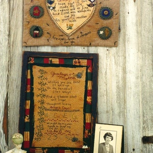 May include: Two framed pieces of needlepoint embroidery with a poem about a mother. The first piece is a heart with the text "Greetings to Mother I hope that I can make my life as radiant and as fine And filled with usefulness and joy As yours is mother mine my treasure-trove of memories for you." The second piece is a poem that reads "Greetings Mother Wishing you the best of blessings On the fairest of life's ways And a gladness that will linger Throughout many Mother's Days! ACEG wrought by my own hands to show my love for you Eme Age 32 1902 23".