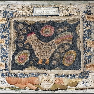 Puede incluir: Una alfombra de punto de aguja vintage con un diseño simple de una gallina marrón con cresta roja y plumas de cola amarillas. La alfombra está rodeada por un borde de patchwork de retazos de tela en tonos azules, blancos y marrones. La alfombra tiene el texto "A SIMPLE LIFE" cosido en la parte superior central.