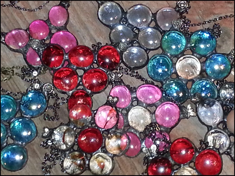 May include: Three glass and metal suncatchers with different colored glass beads. The first suncatcher has red glass beads, the second has pink glass beads, and the third has blue and clear glass beads.