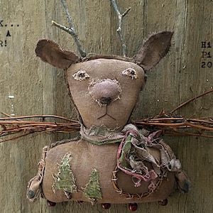 May include: A handmade rustic deer ornament with a brown fabric body, twig antlers, and a brown fabric scarf. The deer is sitting on a wooden surface with the text "Look... it's a deer!" and "Hickety Pickety 2019" visible.