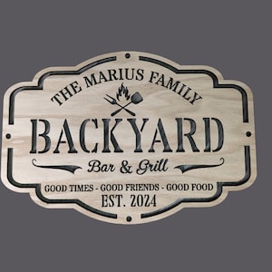 Może przedstawiać: Drewniany znak z tekstem "The Marius Family Backyard Bar & Grill" i tekstem "Good Times - Good Friends - Good Food Est. 2024".
