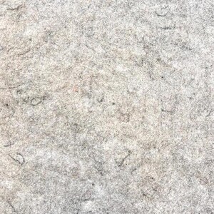May include: A close-up of a textured, gray surface with faint pencil markings.