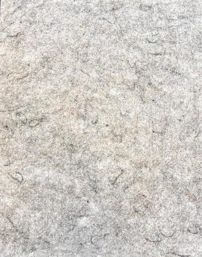 May include: A close-up of a textured, gray surface with faint pencil markings.