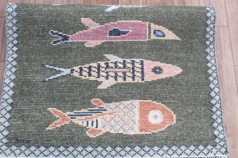 Close view of colorful koi motifs on green hand-knotted wool runner