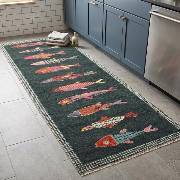 May include: A rectangular runner rug featuring a dark charcoal background with a repeating pattern of stylised fish in various colours including orange, pink, blue, and white. The rug has a chequered border and short fringe on the ends.