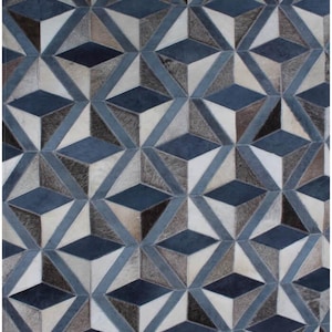 May include: Geometric patterned rug in shades of blue, gray, and white. The rug features a repeating 3D cube design, creating a textured appearance. The rug is made of a soft material, suitable for living rooms or bedrooms.