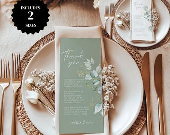 May include: A green thank you card with gold and white floral accents. The card reads "Thank you" and includes a message thanking guests for their presence at the wedding. The card is set on a table with a place setting.