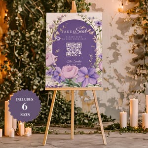 May include: Purple and green floral wedding sign with a QR code and the text "Take a Seat" and "Please scan to find your seat". The sign also includes the text "The Smiths" and "May 16th 2025".