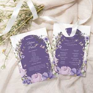 May include: Purple wedding ceremony programme with floral accents. The programme includes the names Thelma & Patrick, the date May 12th, 2023, and the order of the ceremony. The second card is a purple wedding reception programme with floral accents. The programme includes the names of the wedding party, the parents of the bride and groom, and the order of the reception.