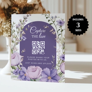 Puede incluir: Un cartel de boda floral morado y blanco con un código QR que dice "Capture the love" y "Por favor, comparte tus fotos con nosotros. Solo escanea y sube".