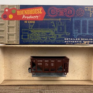 May include: A vintage HO gauge model train car from Roundhouse Products. The box features a red and yellow logo with the text "ROUNDHOUSE PRODUCTS" and "HO GAUGE". The model train car is brown with the text "SOUTHERN PACIFIC" and the number "3245".