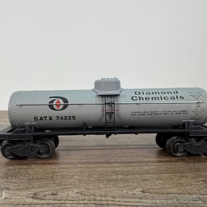 K&ouml;nnte beinhalten: Ein Modell-Eisenbahnwagen mit einem zylindrischen Tank mit der Aufschrift "Diamond Chemicals". Der Tank ist hellgrau mit schwarzer Schrift und einem rot-wei&szlig;en Logo. Der Wagen hat schwarze R&auml;der und eine Leiter. Der Text "GATX 74225" ist ebenfalls sichtbar.