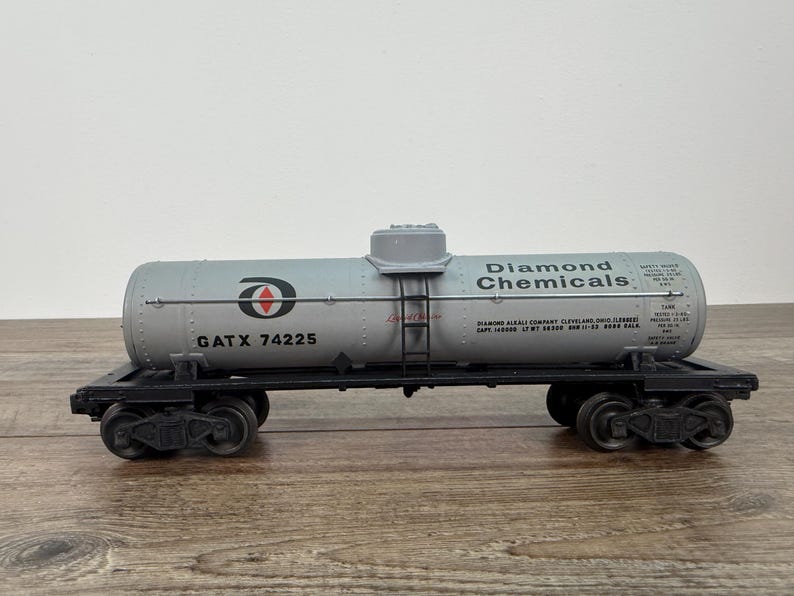 K&ouml;nnte beinhalten: Ein Modell-Eisenbahnwagen mit einem zylindrischen Tank mit der Aufschrift "Diamond Chemicals". Der Tank ist hellgrau mit schwarzer Schrift und einem rot-wei&szlig;en Logo. Der Wagen hat schwarze R&auml;der und eine Leiter. Der Text "GATX 74225" ist ebenfalls sichtbar.