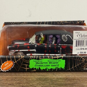 May include: A black toy hearse with red splatter patterns, packaged in a box with spiderweb graphics. The vehicle features a skeleton driver and passenger, purple curtains, and the text Haunted Hearse and Table Accent on the packaging.