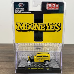 May include: A white ceramic mug with a black handle and the text "But First, Coffee" in a black, handwritten-style font. The mug is on a white surface.