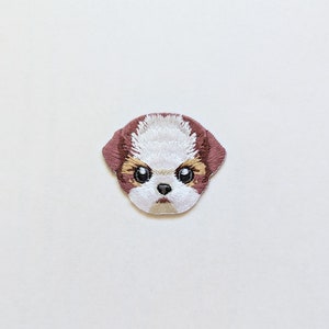 Może przedstawiać: Naszywka haftowana do prasowania przedstawiająca brązowo-białego Shih Tzu o poważnym wyrazie twarzy.