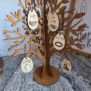 May include: A white ceramic mug with a black handle and the text "But First, Coffee" in a black, bold font. The mug is on a white surface. The mug is approximately 4 inches tall.