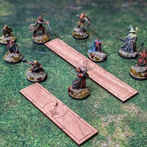 May include: A tabletop game set with miniature figures of characters from the Lord of the Rings. The figures are painted in various colors and are standing on circular bases. There are two wooden game boards with engraved designs.