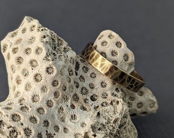 Massief gouden trouwring met gehamerde textuur