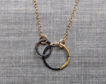Petite ketting met stalen en gouden in elkaar grijpende cirkels