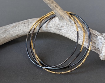 Stapelbare armbanden van staal en goud