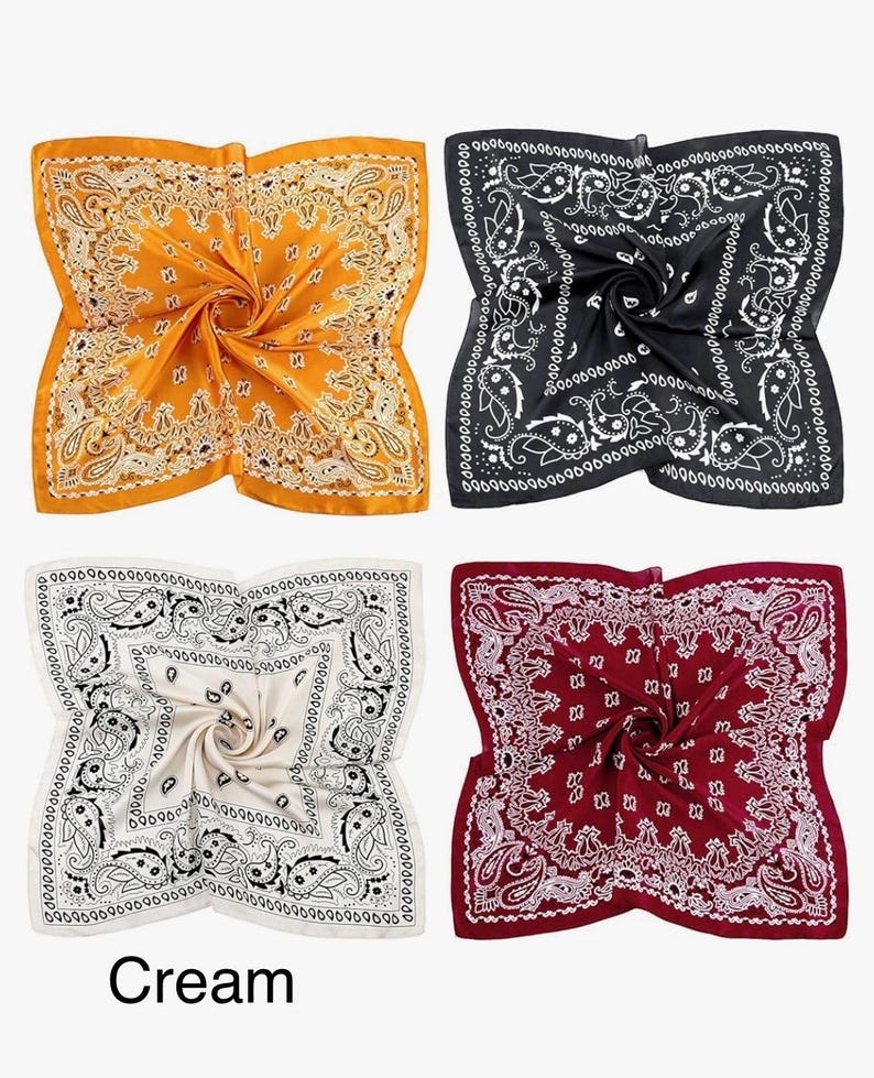 May include: Four square bandanas in different colours: yellow, black, cream, and red. Each bandana has a white paisley pattern.