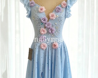 May include: A light blue sleeveless dress featuring a sheer nude-colored neckline, ruffled cap sleeves, and a skirt with a high-low hem. The bodice is decorated with pink and purple fabric flowers, clear crystals, and scattered rhinestones.
