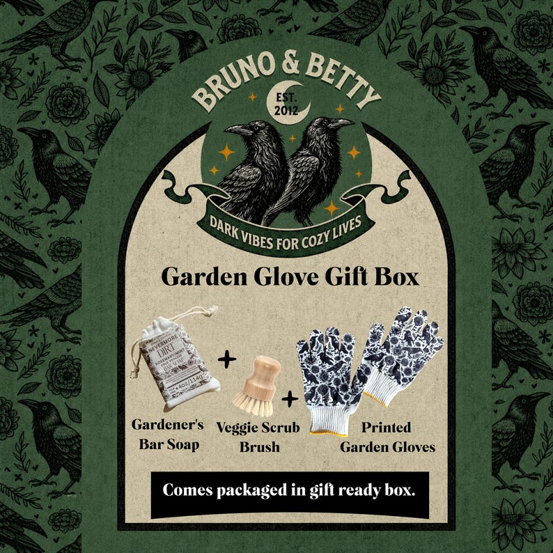 Op de afbeelding: Een tuinhandschoen cadeaupakket met een stuk tuinierszeep, een houten groenteborstel en een paar witte tuinhandschoenen met een zwarte raven- en bloemenprint. De set wordt gepresenteerd met tekstlabels en een ravenlogo.