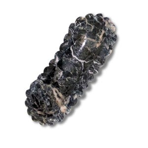 May include: A black and white marble serving dish with a scalloped edge. The dish is shaped like a long oval and has a smooth, polished surface.