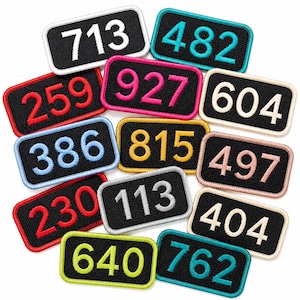 May include: A collection of rectangular embroidered patches with black backgrounds and rounded corners. Each patch features a three-digit number in a different thread color, including white, teal, red, pink, cream, light blue, yellow, peach, gray, lime green, and cyan.