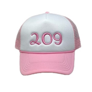 May include: A white and pink trucker hat with the number 209 embroidered in pink on the front.