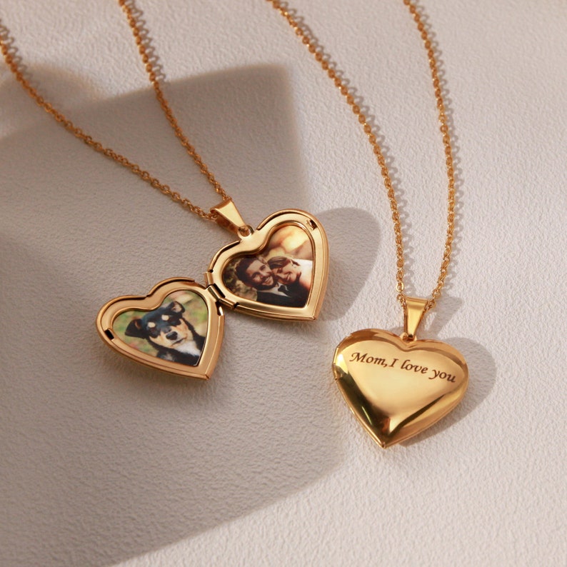 May include: Two gold heart-shaped locket necklaces. One locket contains a photo of a couple, the other has the inscription "Mom, I love you".