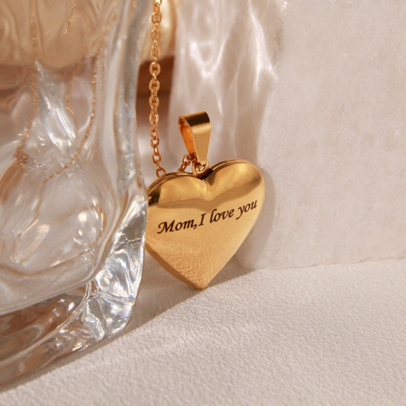 May include: Gold heart-shaped locket necklace with the inscription "Mom, I love you".