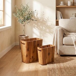 May include: Two wooden storage bins with integrated handles. The bins are rectangular with rounded corners and a natural wood grain finish. The larger bin is approximately 24 inches tall, and the smaller bin is about 18 inches tall. The bins are on a hardwood floor.