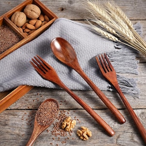 Japanese style wooden spoon and fork set displayed beside a phone for size comparison with measurements shown.