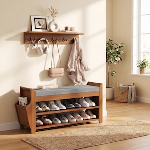 May include: A wooden entryway bench with a gray cushion and shoe storage below. A matching wall shelf above holds a framed picture, vase, and hooks for hanging items like a purse, headphones, and a jacket. A woven rug is on the floor.