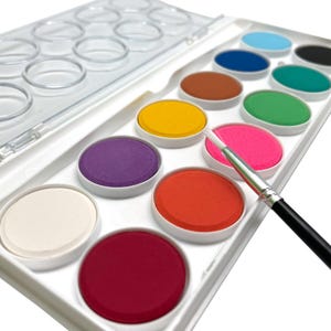 May include: A watercolor paint set with a variety of colors, including yellow, pink, and blue. The set includes a paintbrush and is in a white plastic case. The paints are arranged in individual circular wells.