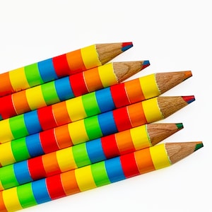 May include: A set of six rainbow colored pencils with multiple colors in each pencil. The pencils are arranged in a fan shape with the tips of the pencils pointing towards the top of the image.