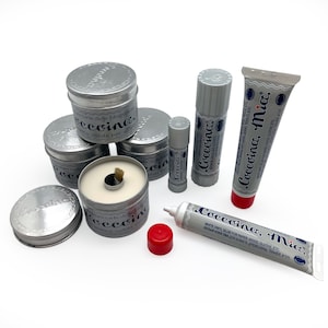 May include: Assortment of silver glue sticks and tubes labeled "Coccoina Mia" in blue and white lettering. The glue is for paper, wood, cloth, and other materials.