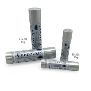 May include: Three glue sticks in different sizes, labeled "Coccoina" in blue and white. The largest glue stick is labeled "Jumbo 40g", the middle glue stick is unlabeled, and the smallest glue stick is labeled "Small 10g".