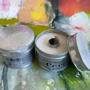 May include: Two silver tins of white glue with a brush attached to the lid. The tin on the right is open and the glue is visible. The text on the tin reads "per incollare carte e tessuti colla bianca"