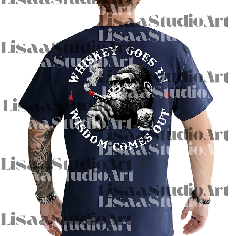 Op de afbeelding: Marineblauw t-shirt met een afbeelding van een gorilla die een sigaar rookt en een glas whisky. De tekst luidt "Whiskey Goes In, Wisdom Comes Out" in een cirkelvormig ontwerp. Een rode bliksem is ook zichtbaar.