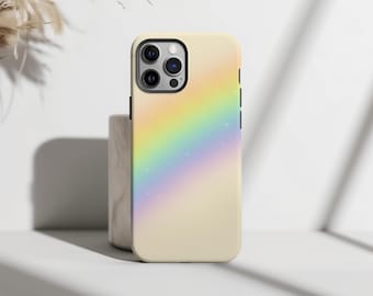 May include: A phone case with a pastel rainbow design. The case has a light yellow base color with a diagonal rainbow gradient in shades of yellow, orange, blue, and purple. Small white stars are scattered across the rainbow. The phone case has a black camera module.
