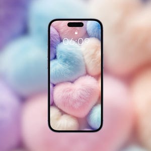 Peut inclure: Un écran de téléphone avec un fond d'écran en forme de cœur flou rose, bleu et blanc. L'heure est 06:09 et le jour est dimanche 4 juin.