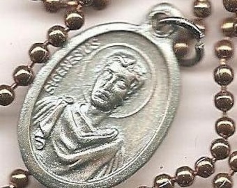 May include: Silver oval pendant with a depiction of Saint Jude Thaddeus, the patron saint of hopeless causes. The pendant is on a silver chain.