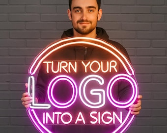 May include: A neon sign with the text "TURN YOUR LOGO INTO A SIGN" in white and pink. The sign is circular with an orange and pink border. The sign is held by a person in front of a gray brick wall.