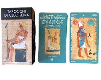 Könnte beinhalten: Ein Tarotkartenspiel mit dem Titel "Tarocchi di Cleopatra" mit einer Schachtel mit einer ägyptischen Figur. Das Deck enthält Karten mit ägyptischen Illustrationen und Text in mehreren Sprachen. Die Karten sind teal mit goldenen Akzenten.