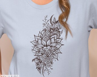 May include: A light blue t-shirt with a brown floral design featuring a large lotus flower and intricate details. The design is centered on the front of the shirt.